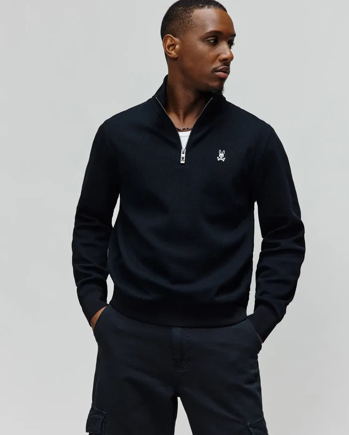 Mens Maxton Waffle 1/4 Zip, a black classic fit pullover with a textured waffle knit, silver zipper, and small white embroidered Psycho Bunny skull logo on the left chest.