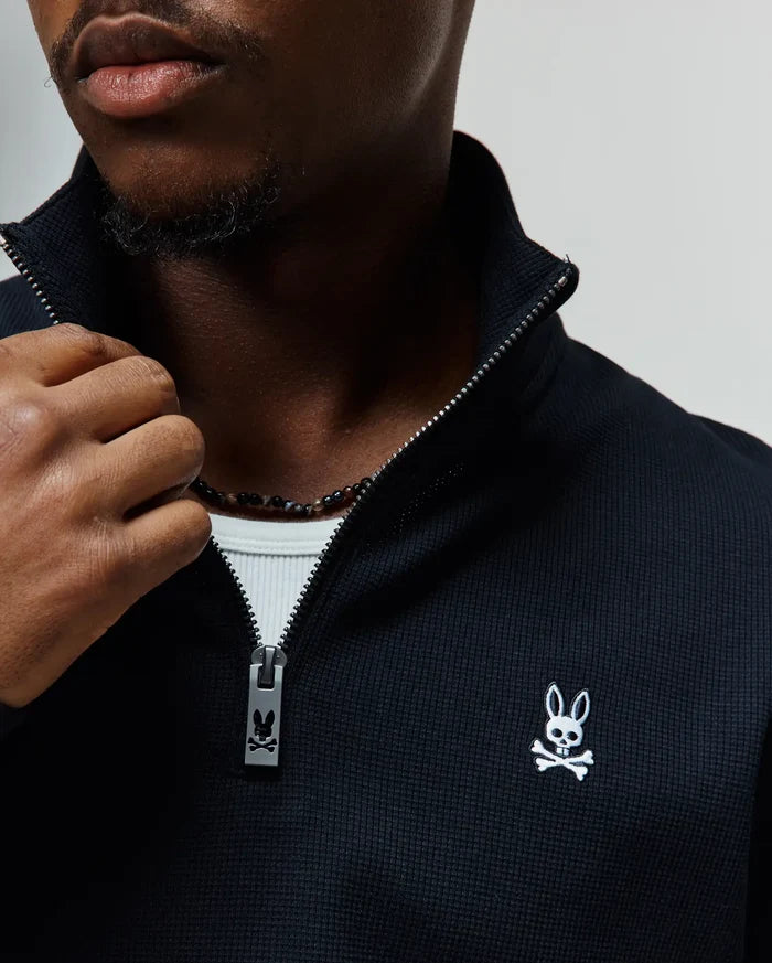 Black Mens Maxton Waffle 1/4 Zip with a textured waffle knit, featuring a small white embroidered Psycho Bunny skull logo on the left chest and a silver branded zipper pull.