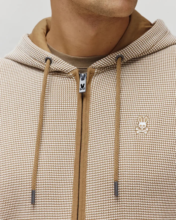 Mens Maxton Waffle Full Zip Hoodie, tan and off-white micro-check waffle knit, classic fit. Features tan drawstrings, metal tips, and a small embroidered Psycho Bunny skull logo on the left chest and zipper pull.