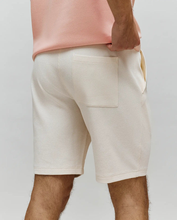 Mens Maxton Waffle Sweatshort in a soft cream hue, featuring a relaxed fit, distinct waffle knit texture, a practical back patch pocket, and convenient side pockets.