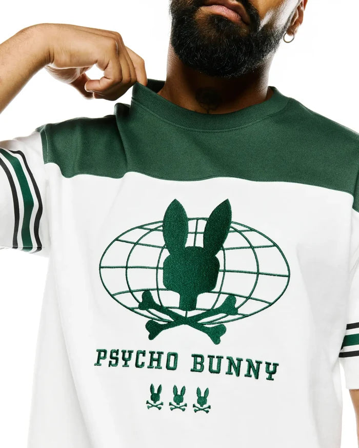 Mens Mike Graphic Jersey Tee, white with green color block. Features an embroidered green Psycho Bunny skull globe graphic, PSYCHO BUNNY text, and three bunny logos on the chest, with striped sleeves.