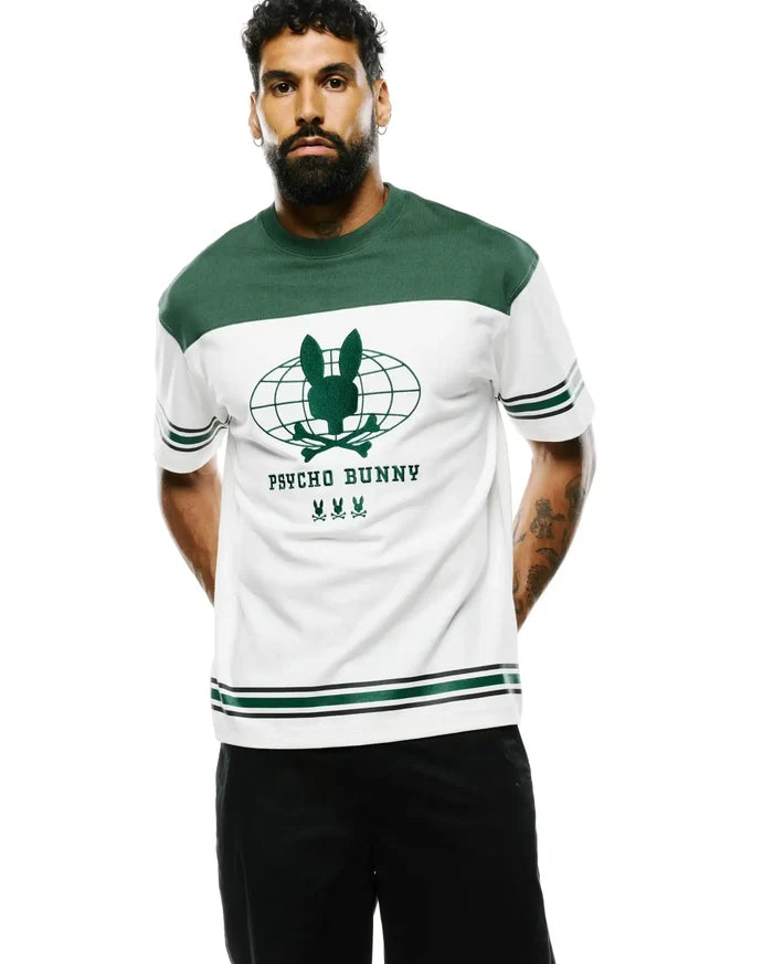 Mens Mike Graphic Jersey Tee, a relaxed fit white jersey tee featuring green color-block shoulders, a large green global bunny skull logo with Psycho Bunny text and three smaller bunny skulls on the chest, finished with green and black striped cuffs and hem.