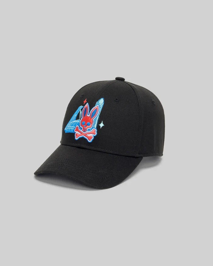 The Psycho Bunny MENS MONTREAL BASEBALL CAP (MO1500048) is a black 100% cotton cap with a Bunny patch featuring a red bunny head, blue ears, crossbones, blue triangle, white star detail on a light gray background.