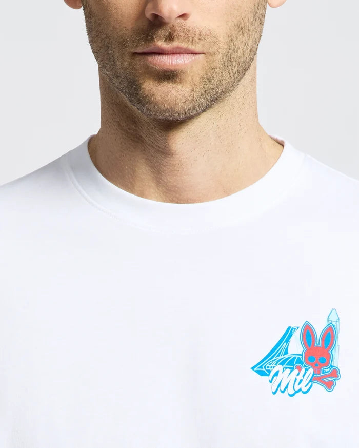A close-up of a man in the Psycho Bunny MENS MONTREAL TEE, made from soft Pima cotton, with a small, colorful chest graphic showing the number 4, "Mil," and a red bunny face with blue ears and a blue sword.