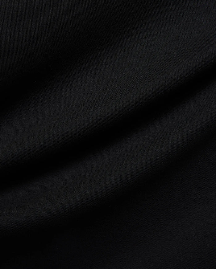 Mens Nasser Interlock Johnny Collar Polo in classic black, featuring smooth interlock fabric and the signature embroidered Psycho Bunny skull logo on the left chest.