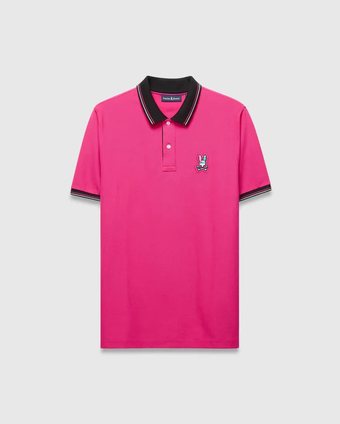 Mens Nate Pique Polo in hot pink pique knit, featuring a classic fit, black ribbed collar with white tipping, matching cuffs, and an embroidered multi-color Psycho Bunny skull logo on the left chest.