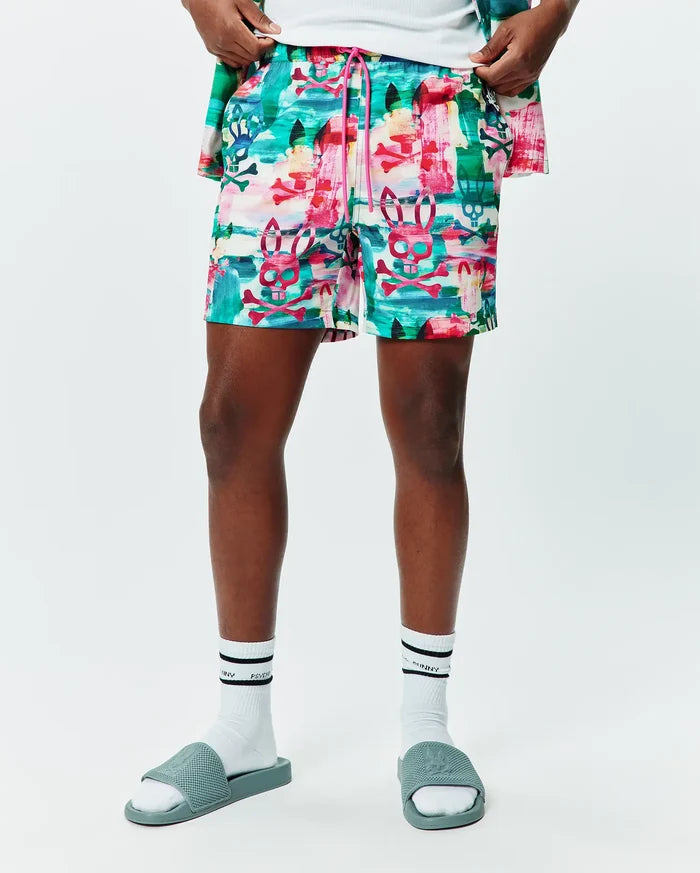 Mens Nate All Over Print Swim Trunk in a vibrant multi-color abstract brushstroke pattern featuring repeated Psycho Bunny skull and crossbones logos, with a pink drawstring, offering a relaxed fit.