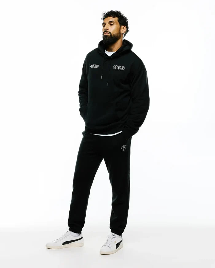 Black relaxed fit French terry hoodie with white Psycho Bunny text and three circular bunny skull logos on chest, paired with Mens Nathaniel Sweatpant featuring a white circular bunny skull logo on left thigh.