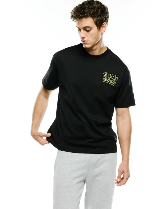 Men's Nathaniel Oversized Pima Tee, black, featuring a small neon yellow Psycho Bunny logo print with three bunny skulls and brand text on the left chest, in a soft jersey fabric.