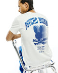 Mens Nathaniel Back Graphic Tee, a classic fit white jersey t-shirt featuring a large blue Psycho Bunny text and striped bunny skull logo graphic on the back, with New York Since 2005 branding.