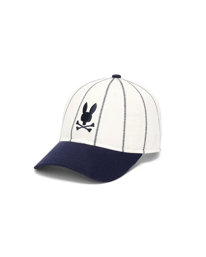Mens Nathaniel Soft Baseball Cap featuring a cream crown with vertical navy dash stitching, a navy brim, and a front-center embroidered navy Psycho Bunny skull logo.