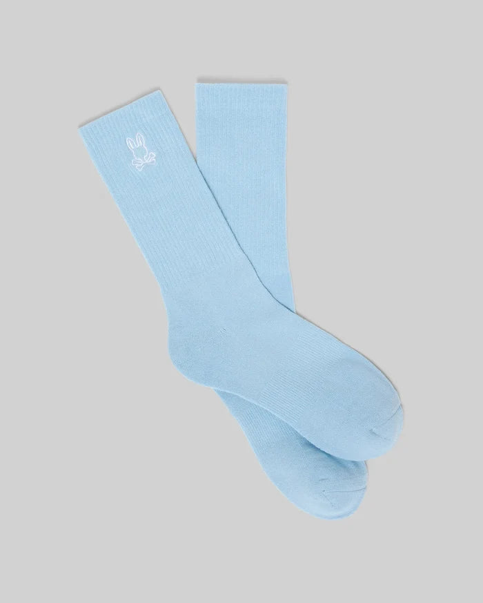 Mens New Classic Sport Sock, light blue, with a white embroidered Psycho Bunny skull logo prominently displayed on the ribbed cuff, featuring a smooth knit body.