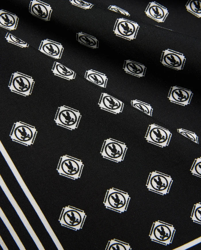 Mens Nick Tencel Short 7, black fabric with all-over white Psycho Bunny skull logo pattern in square frames, featuring bold white diagonal stripes. Smooth Tencel texture.