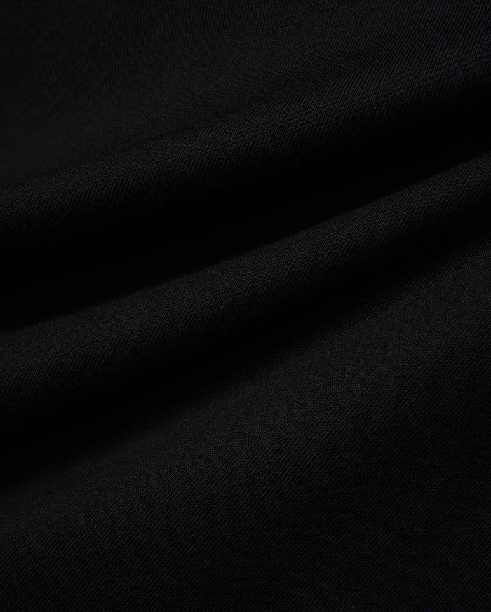 Mens Norman Long Sleeve Oversized Fit Tee in rich, solid black, showcasing a premium, soft-touch jersey knit fabric with a subtle, fine diagonal texture and natural draping folds.