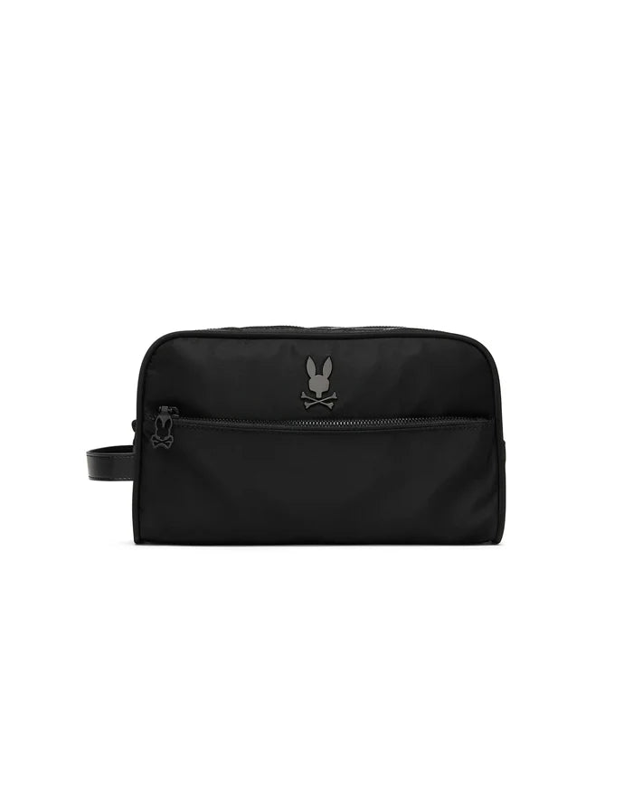 Black Mens Nylon Dopp Kit with a smooth nylon texture, featuring a prominent gunmetal Psycho Bunny skull logo on the front, a zippered front pocket, and a wrist strap with a smaller logo on the zipper pull.