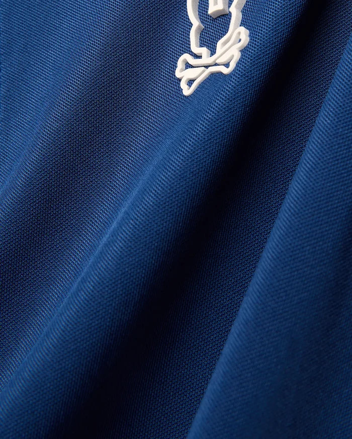 Mens Odin Zip Sport Polo in royal blue pique knit fabric, featuring a small white embroidered iconic Psycho Bunny skull logo on the chest.