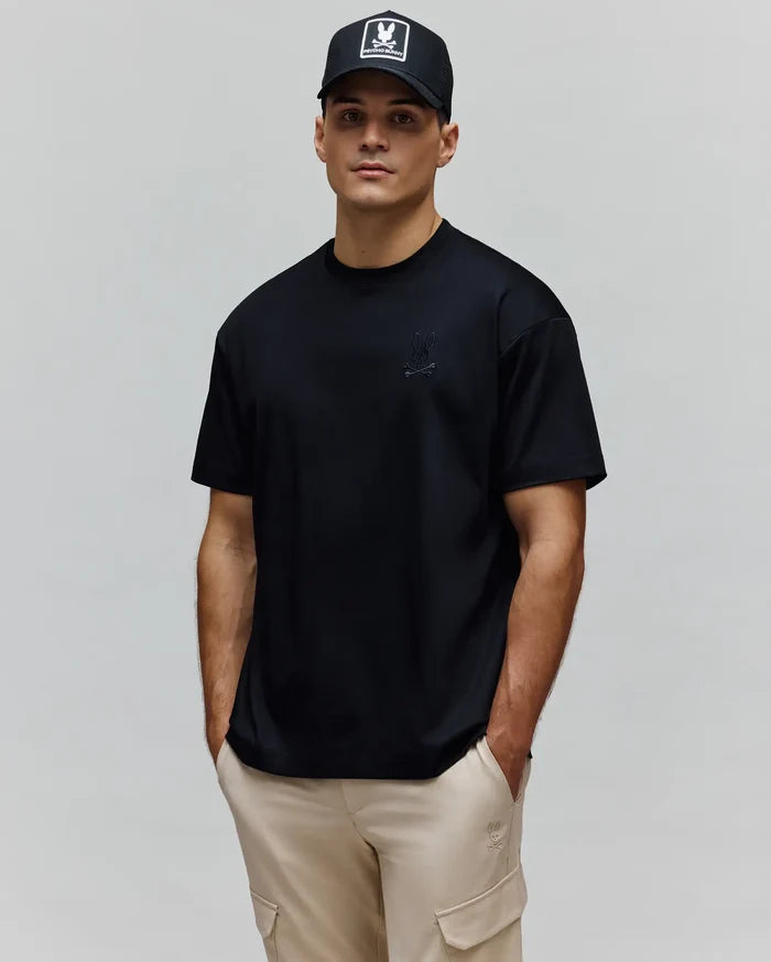 Mens Oscar Oversized Tee, a black jersey knit t-shirt with a relaxed fit, featuring a small, tonal embroidered Psycho Bunny skull logo on the left chest.
