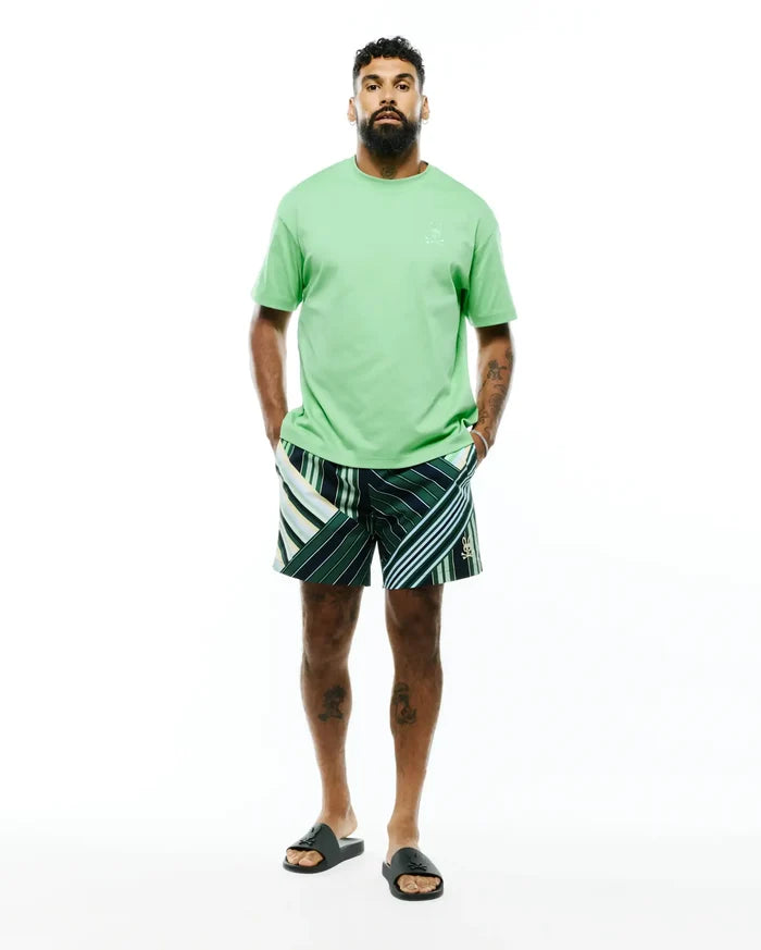 Mens Oscar Relaxed Fit Tee in light green jersey with a tonal embroidered bunny skull on the left chest, paired with dark green striped shorts featuring white, light green, and yellow accents and a small embroidered bunny skull on the leg.