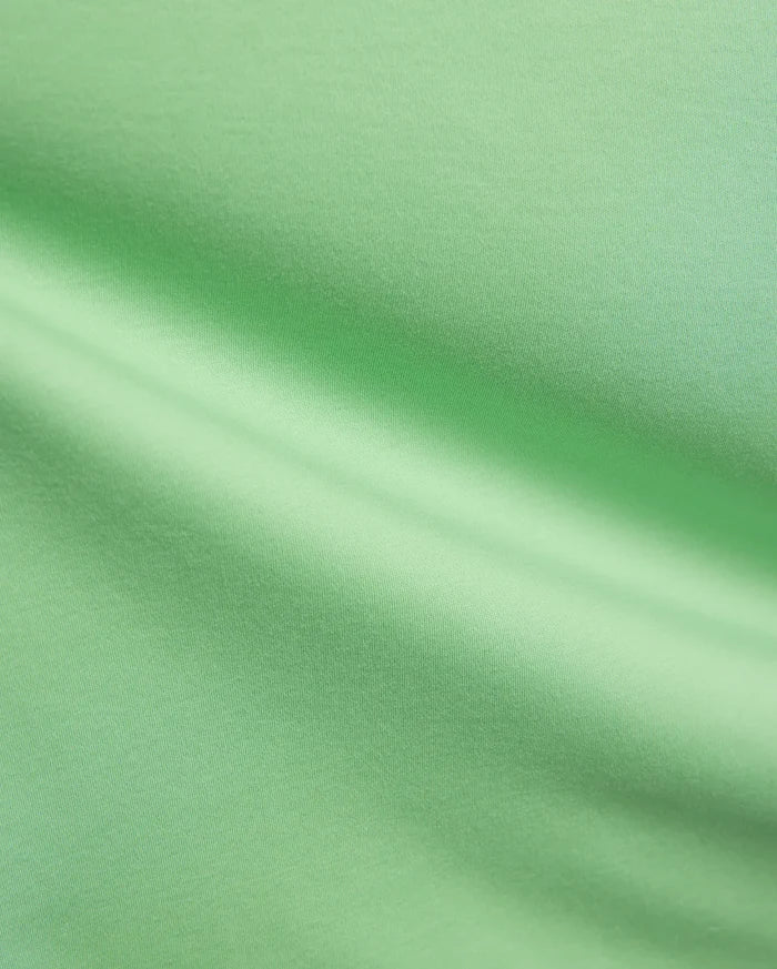 Mens Oscar Relaxed Fit Tee in a fresh, vibrant light green, premium soft jersey knit fabric, highlighting its smooth, breathable texture and elegant, relaxed drape with subtle folds and shadows.