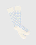 Mens Outline Bunny Dress Sock in cream with a vibrant light blue all-over embroidered Psycho Bunny skull logo pattern, crafted from a smooth knit fabric.
