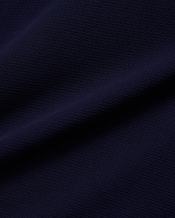 Psycho Bunny Mens Peter Knit Vest fabric in deep navy blue, featuring a premium, subtly textured knit surface, reflecting the brand's refined streetwear aesthetic.