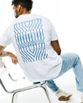 Mens Piers Pima Cotton Back Graphic Tee, a classic fit white jersey t-shirt featuring a large, bold blue stacked PSYCHO BUNNY text graphic covering the entire back.
