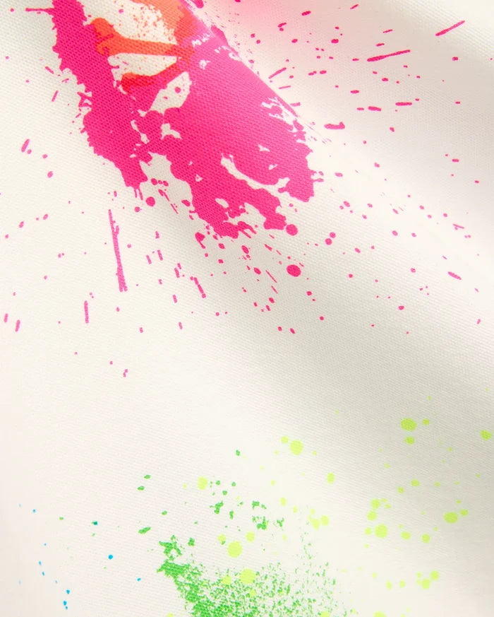 Mens Quintin Aop Pique Polo in crisp white pique fabric, adorned with a bold all-over paint splatter print in vibrant hot pink, neon green, bright orange, and subtle light blue.