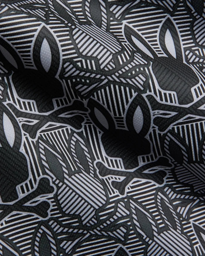Mens Reeves All Over Bunny Sport Polo in black, white, and grey, featuring an all-over Psycho Bunny skull and crossbones print on a geometric striped performance fabric.
