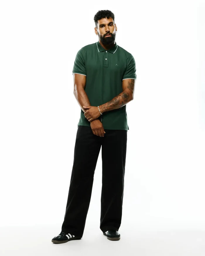 Mens Ringston Pique Polo, a classic fit dark green pique polo with white tipped collar and cuffs, featuring a small embroidered Psycho Bunny skull logo on the left chest.