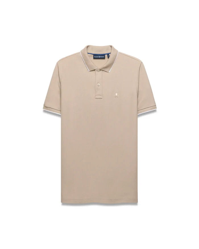 Mens Ringston Pique Polo in beige, featuring a classic fit, textured pique fabric, white tipping on the ribbed collar and cuffs, and a small embroidered Psycho Bunny skull logo on the left chest.