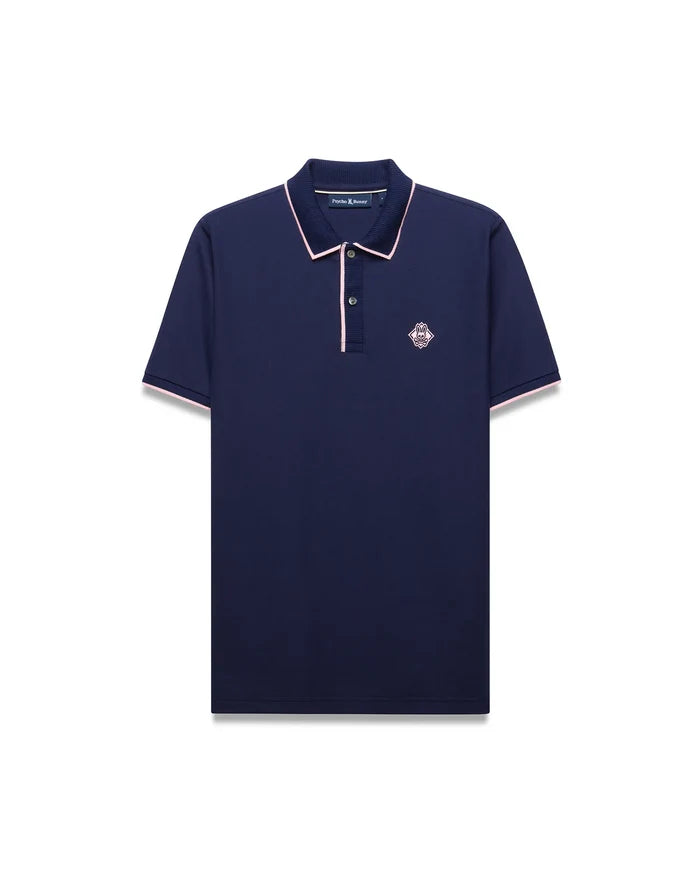 Mens Robin Pique Polo in navy pique with pink trim on the collar, placket, and sleeve cuffs, featuring an embroidered pink Psycho Bunny skull logo on the left chest.