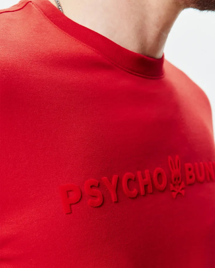 Red Mens Royce Graphic Tee in smooth jersey knit, featuring a large, central, raised velvety red PSYCHO BUNNY text with the iconic bunny skull logo, classic fit.