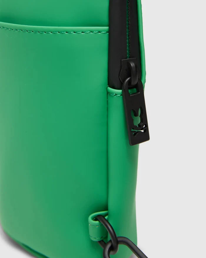 Mens Rubberized Crossbody in bright green with a smooth, rubberized finish, featuring a black zipper, hardware, and a small Psycho Bunny skull logo cutout on the zipper pull.