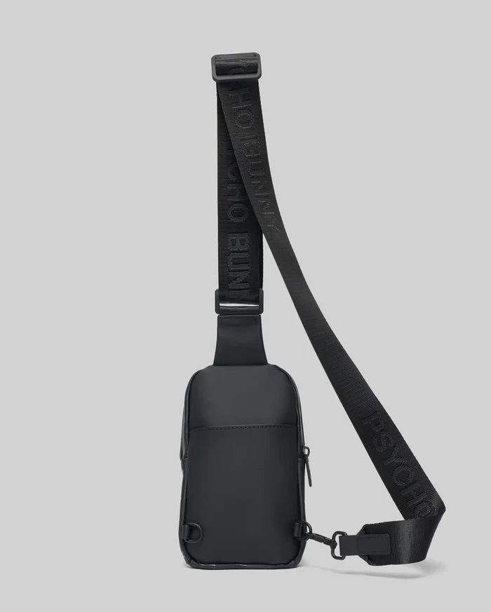 Black Mens Rubberized Crossbody bag featuring a sleek, smooth finish, an adjustable woven strap with repeated Psycho Bunny text logo, and secure zippered compartments.