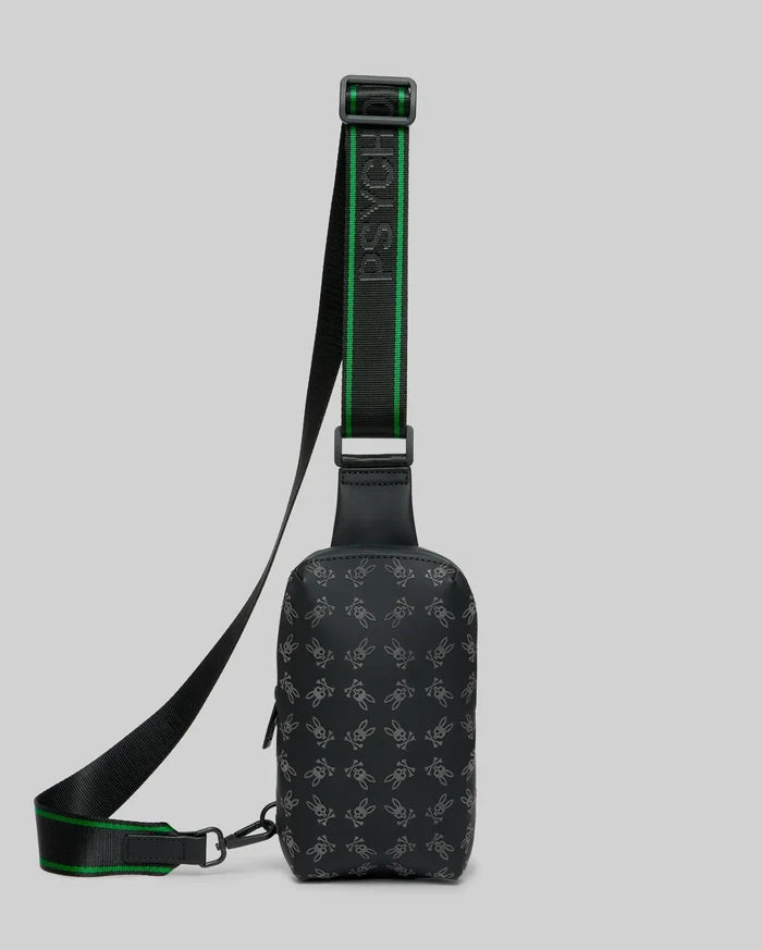 Mens Rubberized Crossbody in black, featuring an all-over subtle grey Psycho Bunny skull logo pattern and a black woven strap with bold green stripes and repeated Psycho Bunny text.