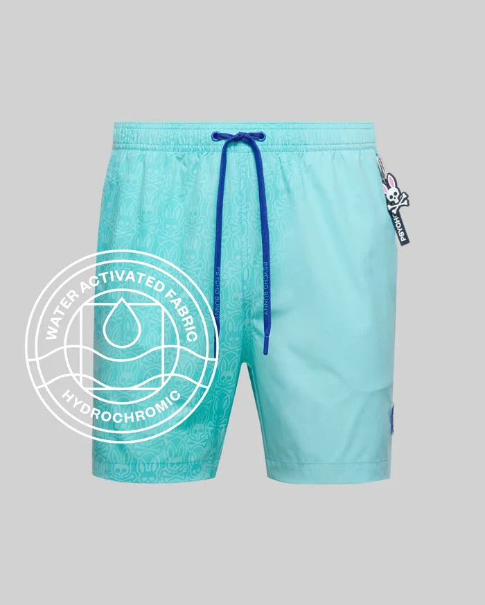 Mens Samos Hydrochromic Printed Swim Trunk in aqua with royal blue drawstrings, featuring a subtle water-activated bunny skull pattern and a small Psycho Bunny logo patch. Relaxed fit, smooth quick-dry fabric.