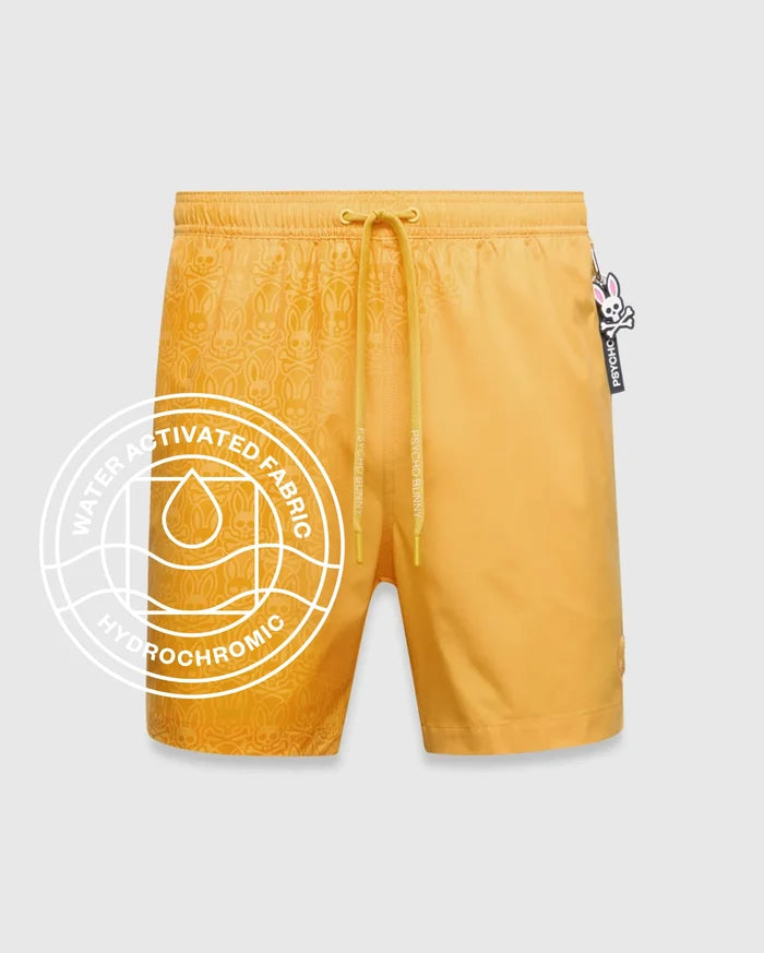Goldenrod yellow Mens Samos Hydrochromic Printed Swim Trunk with a water-activated tonal bunny skull pattern, elastic drawstring waist featuring Psycho Bunny text, and a small embroidered logo.