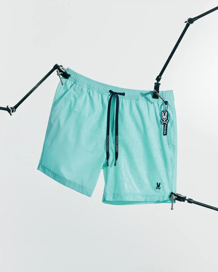 Mens Samos Hydrochromic Printed Swim Trunk 6 in aqua with a subtle hydrochromic bunny skull pattern, black Psycho Bunny drawstrings, and a small embroidered bunny skull logo.