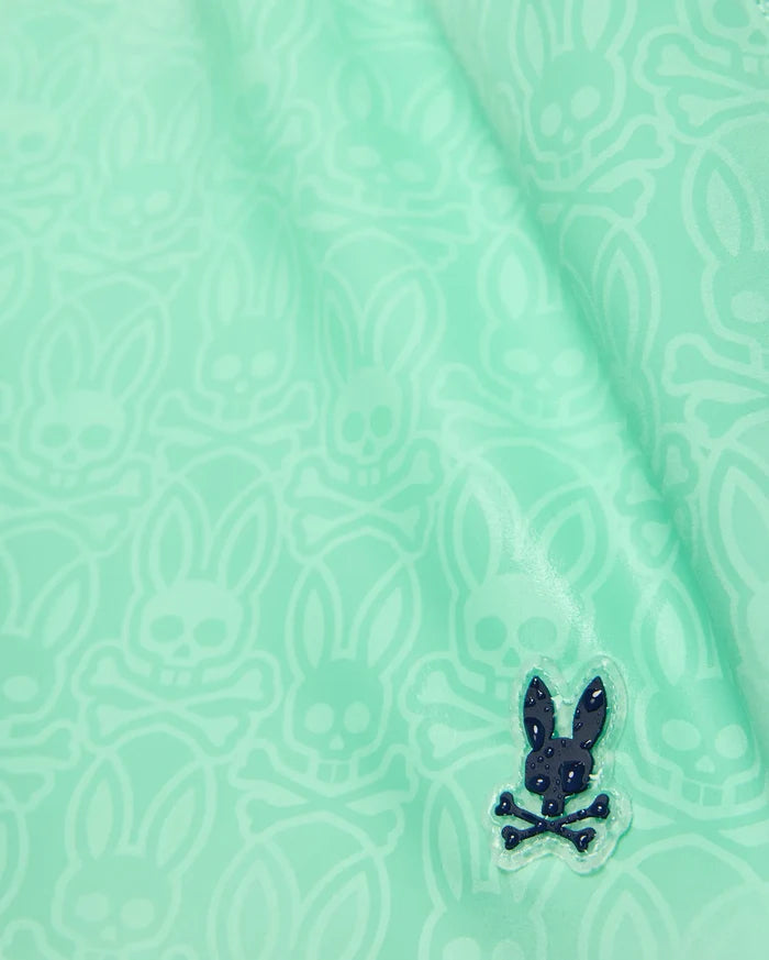 Samos Hydrochromic Printed Swim Trunk 6 in mint green, featuring a subtle all-over Psycho Bunny skull logo pattern and a small rubberized dark blue bunny skull emblem on smooth fabric.