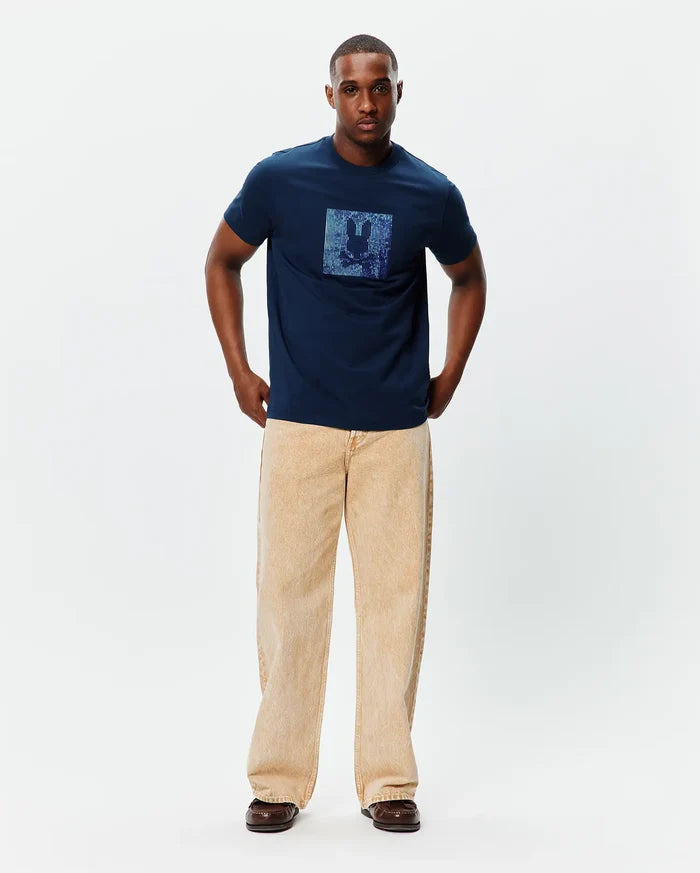 Mens Seamus Graphic Tee, a classic fit navy blue jersey t-shirt featuring a large, centered, iridescent blue and purple pixelated Psycho Bunny skull logo graphic on the chest.