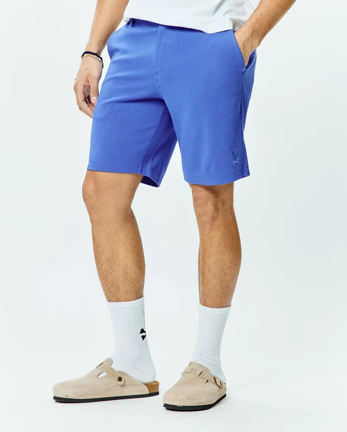 Mens Shiro Twill Short in vibrant blue, featuring a classic fit and subtle twill texture. A small, embroidered Psycho Bunny skull logo is visible on the lower left leg.