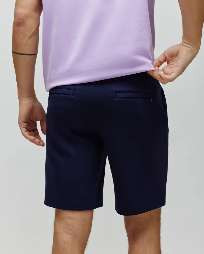 Mens Shiro Twill Short in classic fit navy blue twill fabric, featuring back welt pockets and a subtle Psycho Bunny text logo on the right rear pocket.