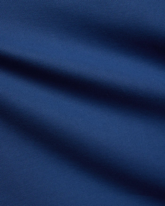 Mens Stan Pique Polo in a rich, deep blue, highlighting the classic textured pique weave, a premium and breathable fabric from Psycho Bunny menswear.