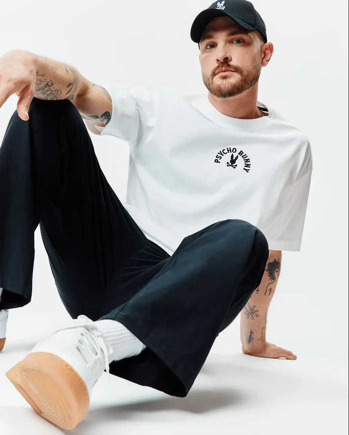Mens Stevie Relaxed Fit Tee, white smooth jersey, featuring a black arched Psycho Bunny text and iconic bunny skull logo centered on the chest.