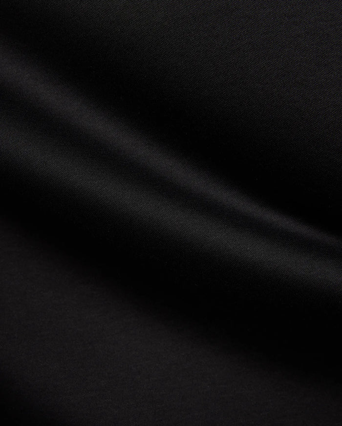 Psycho Bunny Mens Stevie Relaxed Fit Tee in deep black, made from smooth jersey fabric with subtle texture, featuring the iconic small embroidered bunny skull logo on the left chest.