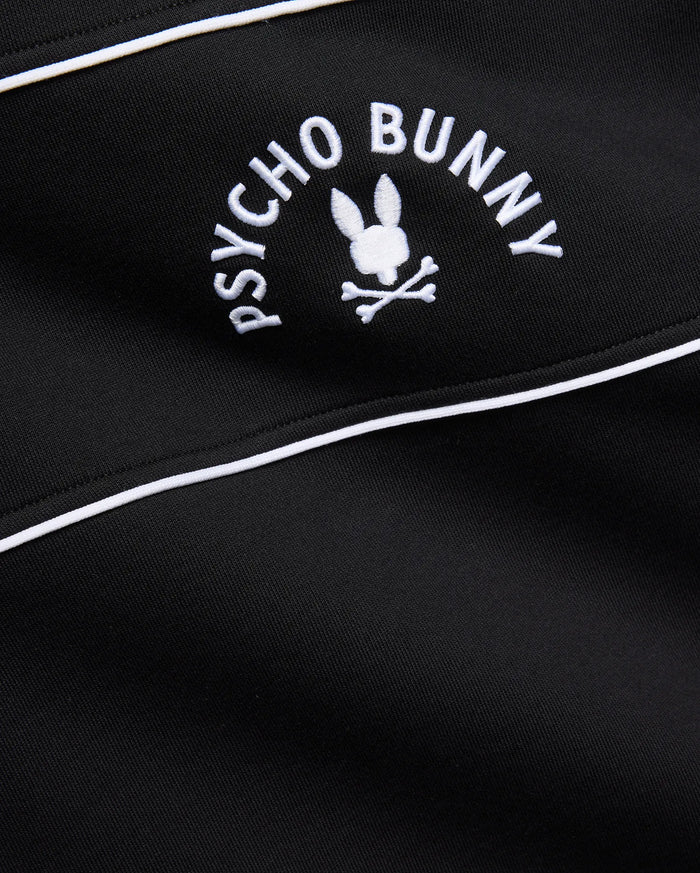 Mens Stevie French Terry Ss 1/4 Zip in black french terry, featuring a prominent white embroidered Psycho Bunny skull logo with curved text and white piping detail.