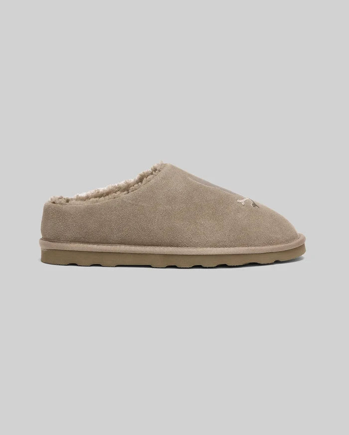 Mens Suede Sherpa Bunny Slipper in tan, featuring a soft suede exterior, plush sherpa lining, and a subtle embroidered Psycho Bunny skull logo on the front.
