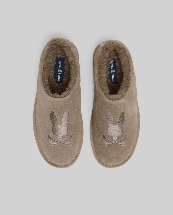 Mens Suede Sherpa Bunny Slipper in taupe, featuring a plush brown sherpa lining and a large embroidered Psycho Bunny skull logo on the toe, with brand text on the insole.