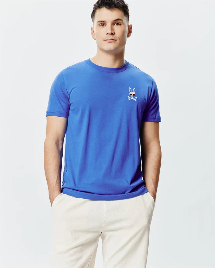 Mens Sunny Chest Graphic Tee, royal blue classic fit jersey knit t-shirt with a small embroidered Psycho Bunny skull logo featuring red sunglasses and white crossbones on the left chest.