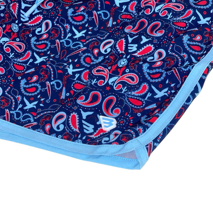 Burlebo Patriotic Paisley Men's Swim Trunks, sizes S-XXL. Close-up of bottom hem and pattern details, showcasing light blue trim and Burlebo logo on red, white, and blue paisley fabric.